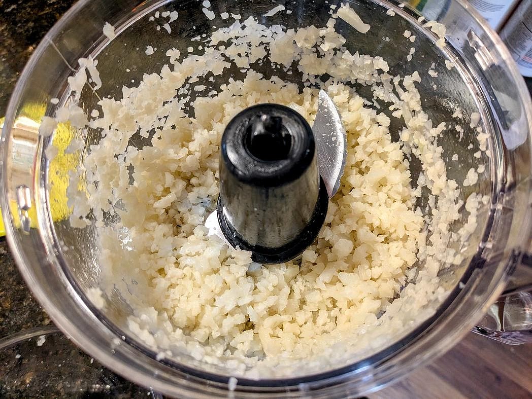 In a food processor, pulse thawed cauliflower in batches until you have the texture of rice. Don't over blend or it will end up mushy and watery. Add the cauliflower to a large bowl.