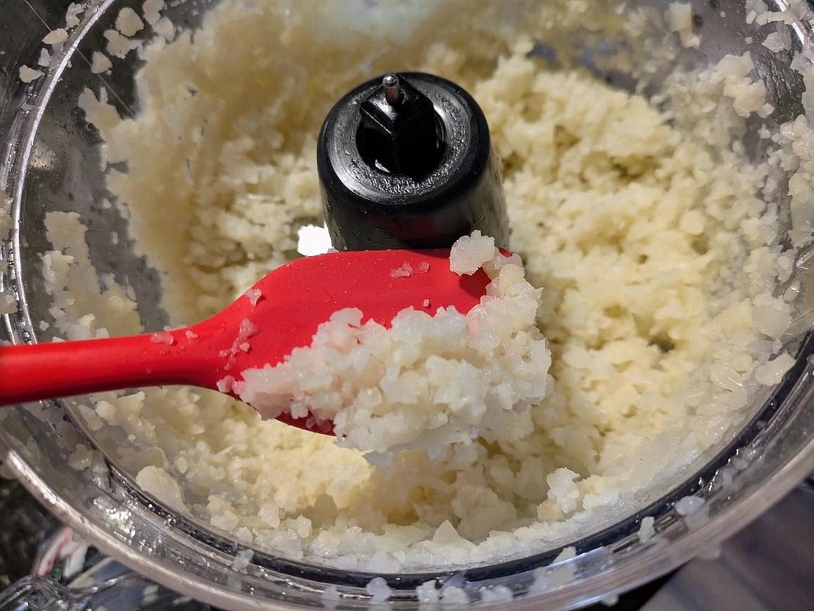 In batches, pulse your thawed cauliflower in a food processor until you end up with a rice consistency. Don't over blend, or it will end up watery and mushy. Transfer the cauliflower to a large bowl.