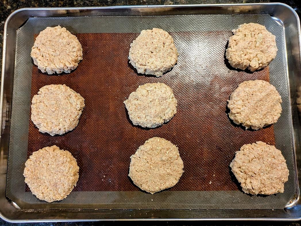 Divide your dough into 9 equal balls, about 66 g each. Add to the cookie sheet, lightly flatten down, and shape into a circle.