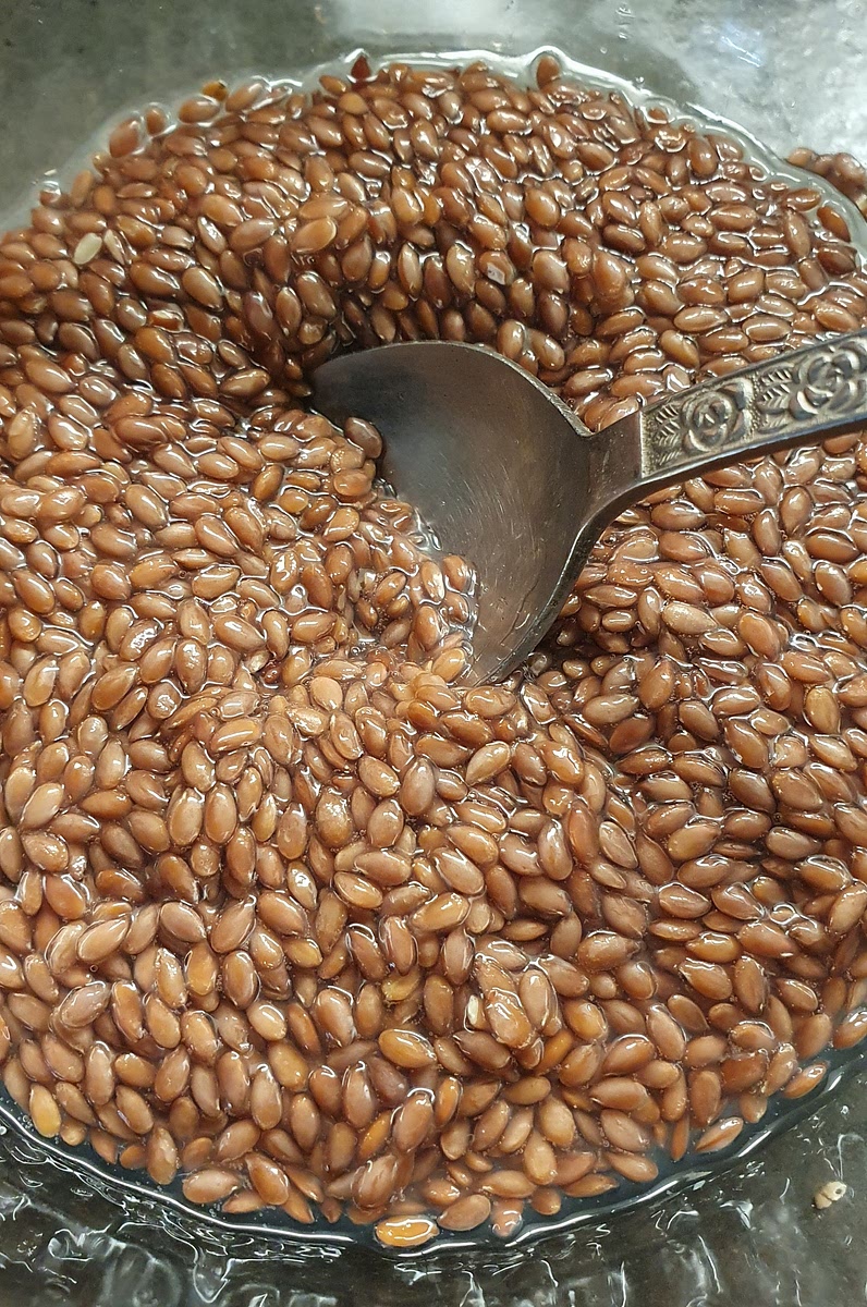 Your linseeds have drawn in the water, now they will be easier to digest and give more nutrients.
Yes, they should be slimy, it will help protect your stomach.
A quick rinse wont hurt if you want to.