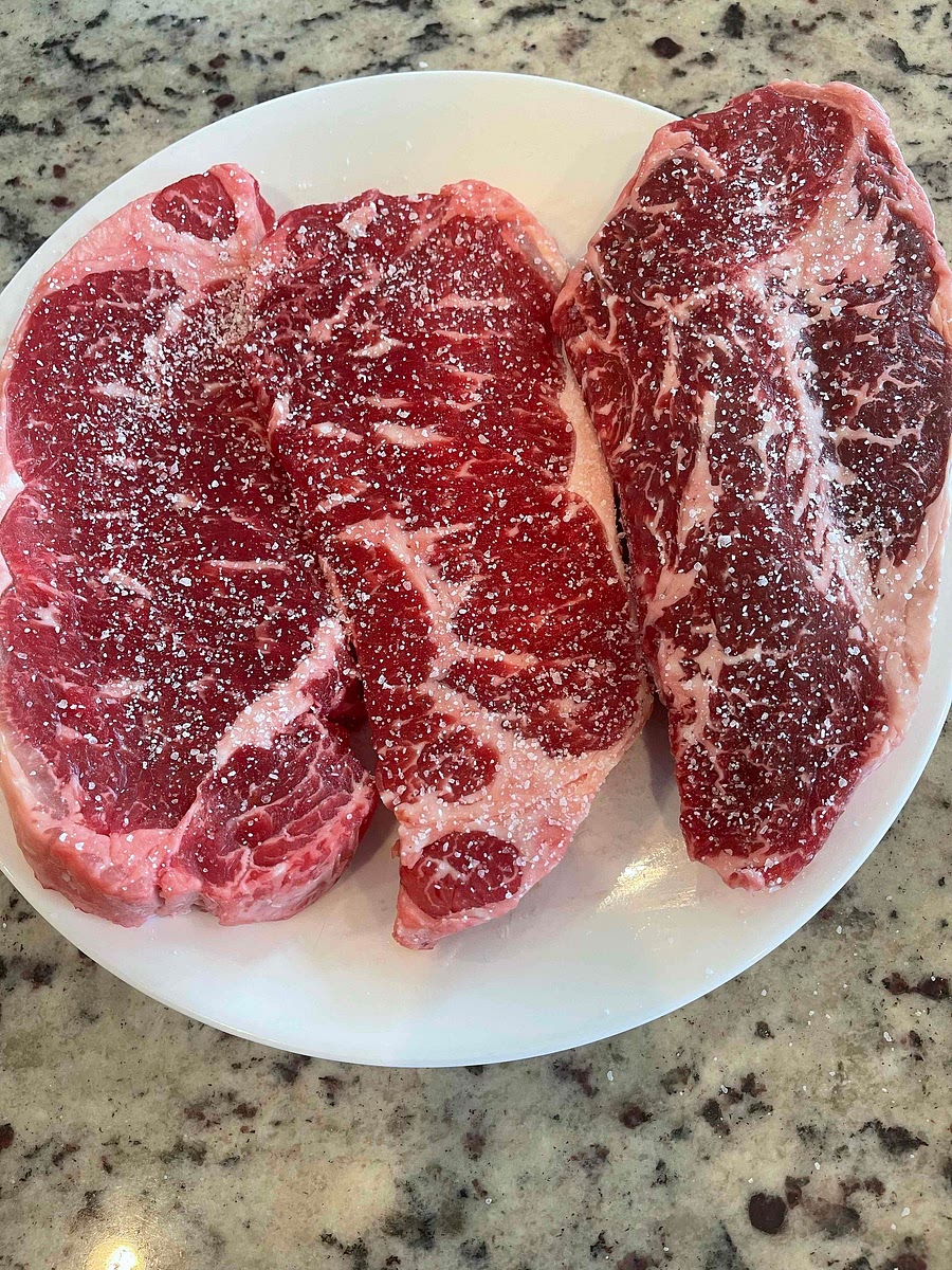 It’s best to take your steak out of the freezer or fridge and salt it. Salt all sides and leave it out , or in the fridge for an hour to let the salt penetrate. You CAN skip this step for a less tasty steak.