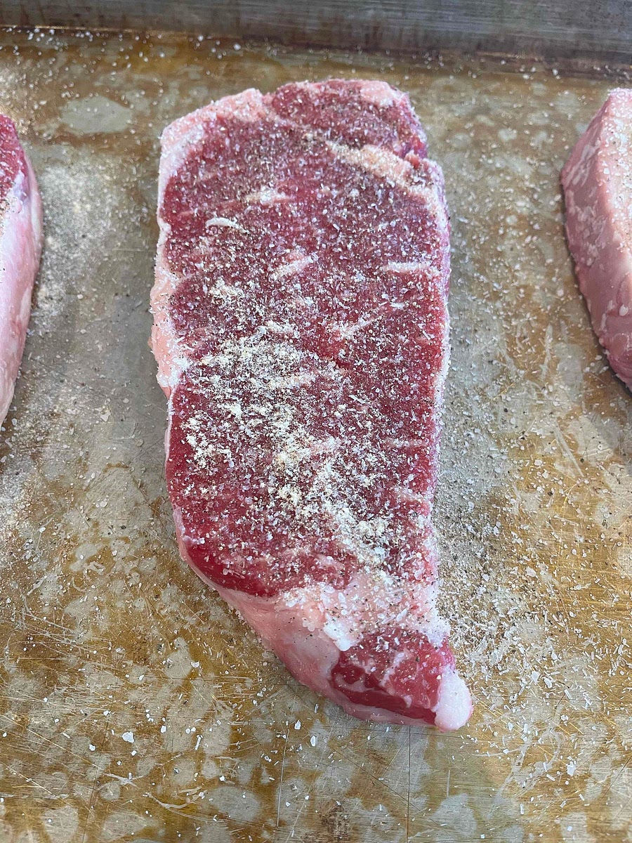 As the oven is heating up, season your steak. Generously season (more than you might expect) all sides of your steak with salt, pepper and garlic powder.