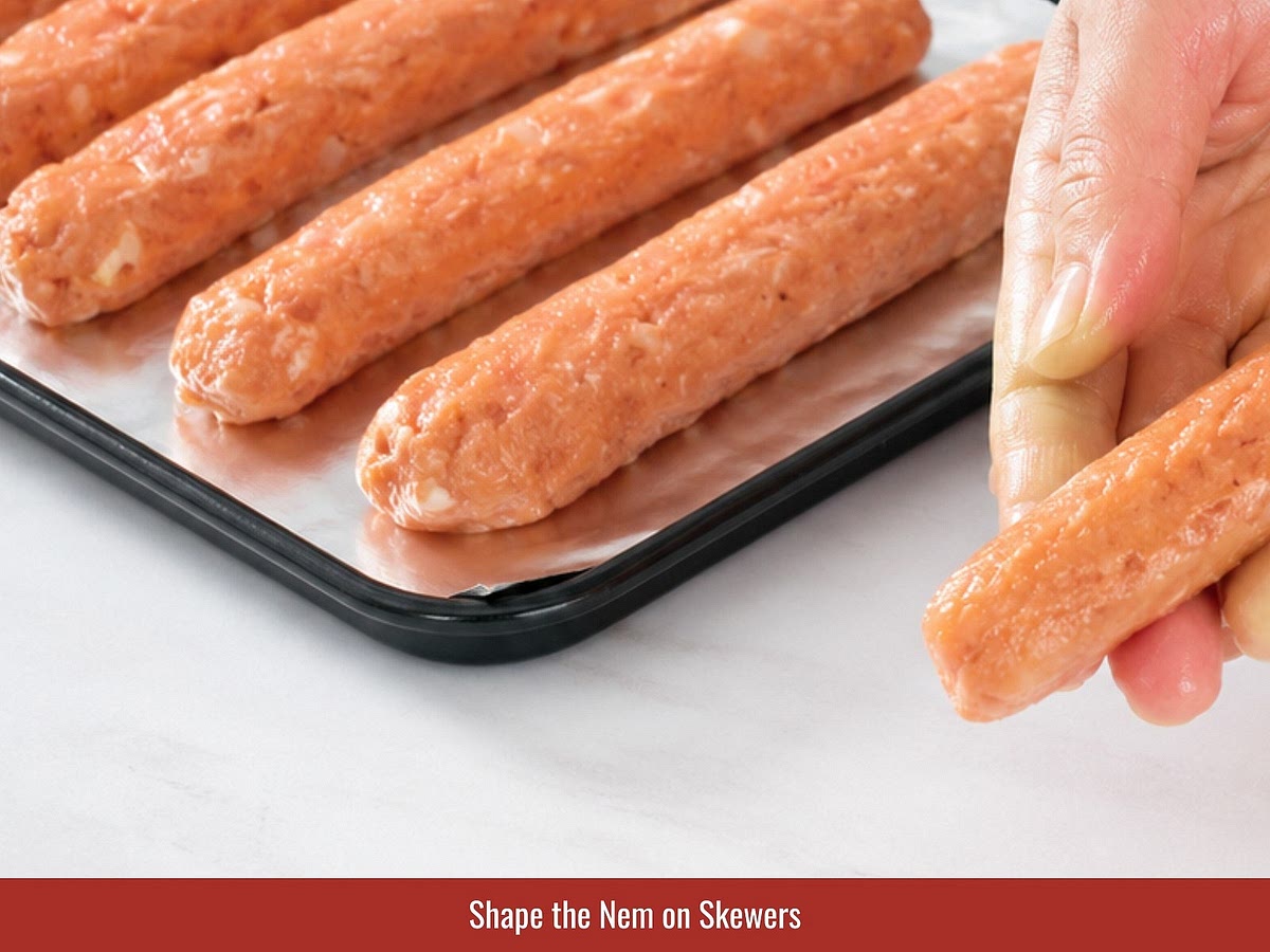 Coat hands with oil, divide the pork mixture into portions, and shape each portion evenly around bamboo skewers.