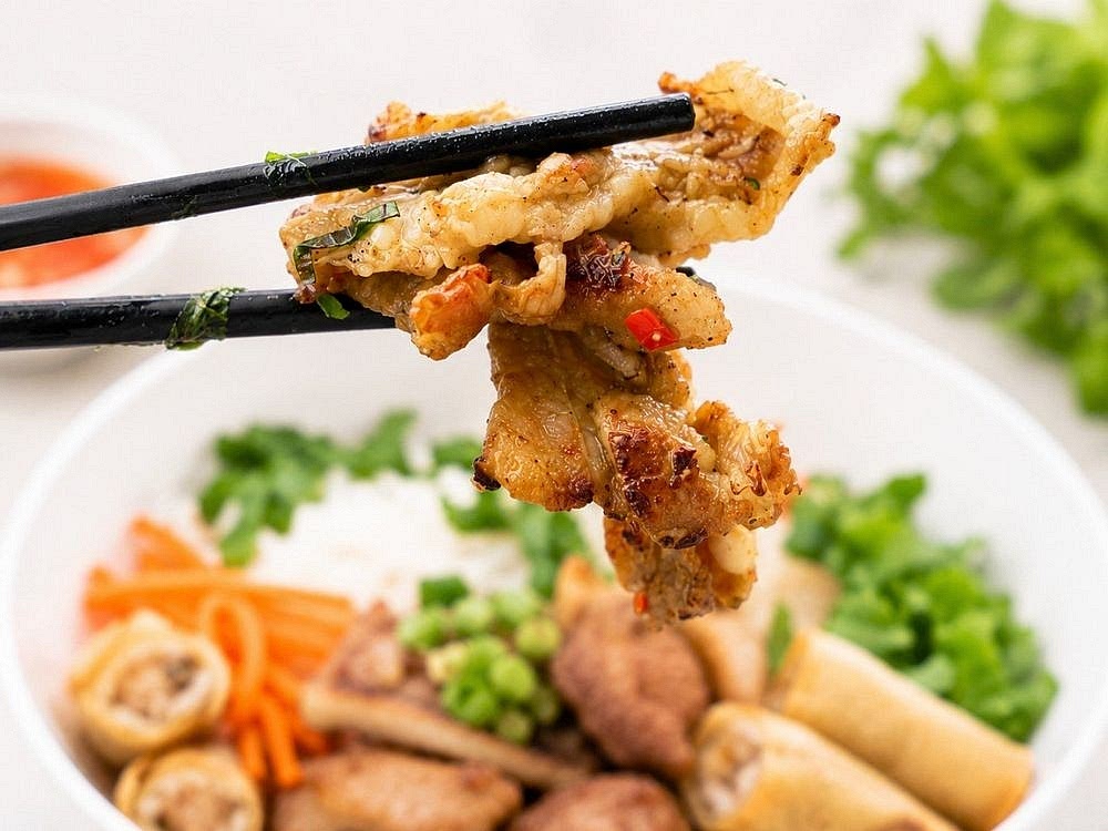 Place vermicelli in serving bowls, add vegetables and herbs, top with grilled pork, pickled vegetables, roasted peanuts, and scallion oil. Pour nước chấm over the bowl before eating.