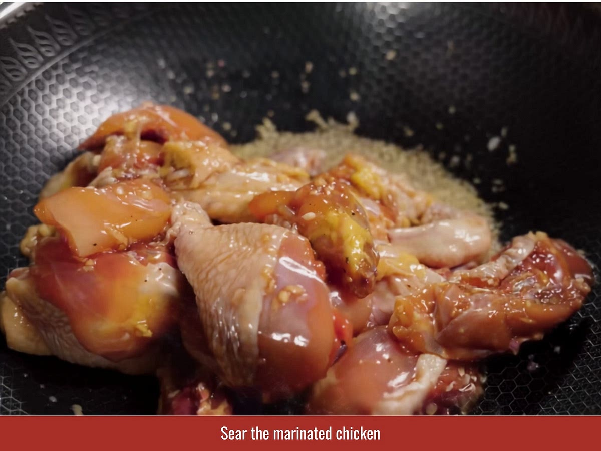 Add the marinated chicken and cook until the outside firms and becomes coated with the caramel sauce. This develops deeper flavor before braising.