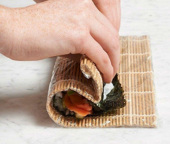 You need to rinse the sushi rice until the water runs clear. Put it in a pot or rice cooker and add water so that it is 1.5 cm above the rice. After the rice is cooked, stir in a mixture of warm vinegar mixed with cane sugar. Let the rice cool down a bit. Once it has cooled down, make sure that you always have wet hands when filling the sushi seaweed, otherwise the rice will stick to you. Fill it with things you like ( like cream cheese, salmon, avocado and cucumber), wrap it and let it cool in the fridge. Serve with soy sauce.