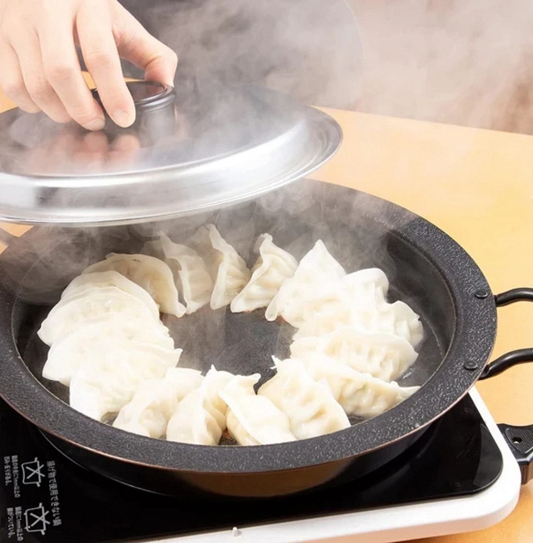 After filling all the dough pieces with meat, heat a pan with oil and fry the dumplings on a low flame. After they have a crust, pour 100 ml of water into the pan, cover it with a lid and let it simmer for about 5 minutes.