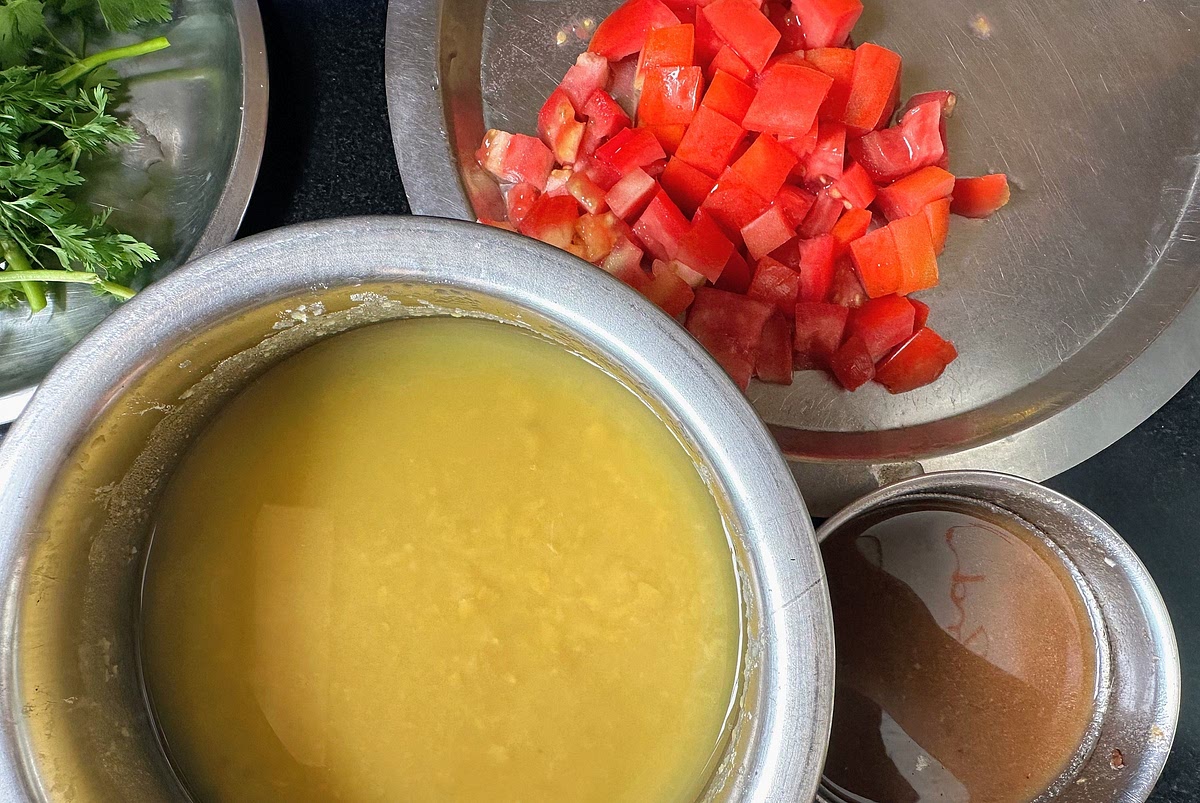Dice tomatoes into small cubes. Chop coriander leaves. Soak tamarind in water for 15-20 mins. Squeeze out the water from the tamarind and keep the juice aside.