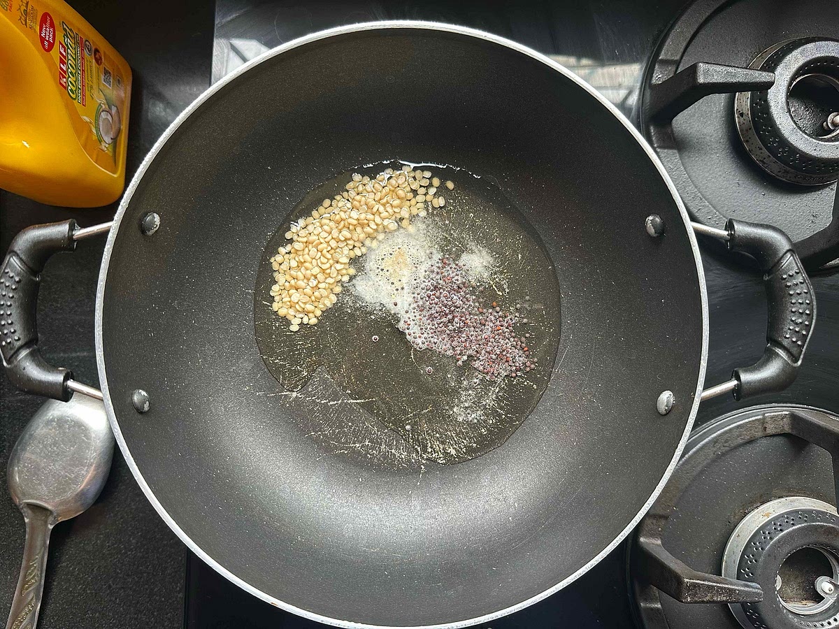 In a kadhai, heat coconut oil. Add hing, mustard seeds and ural dal.