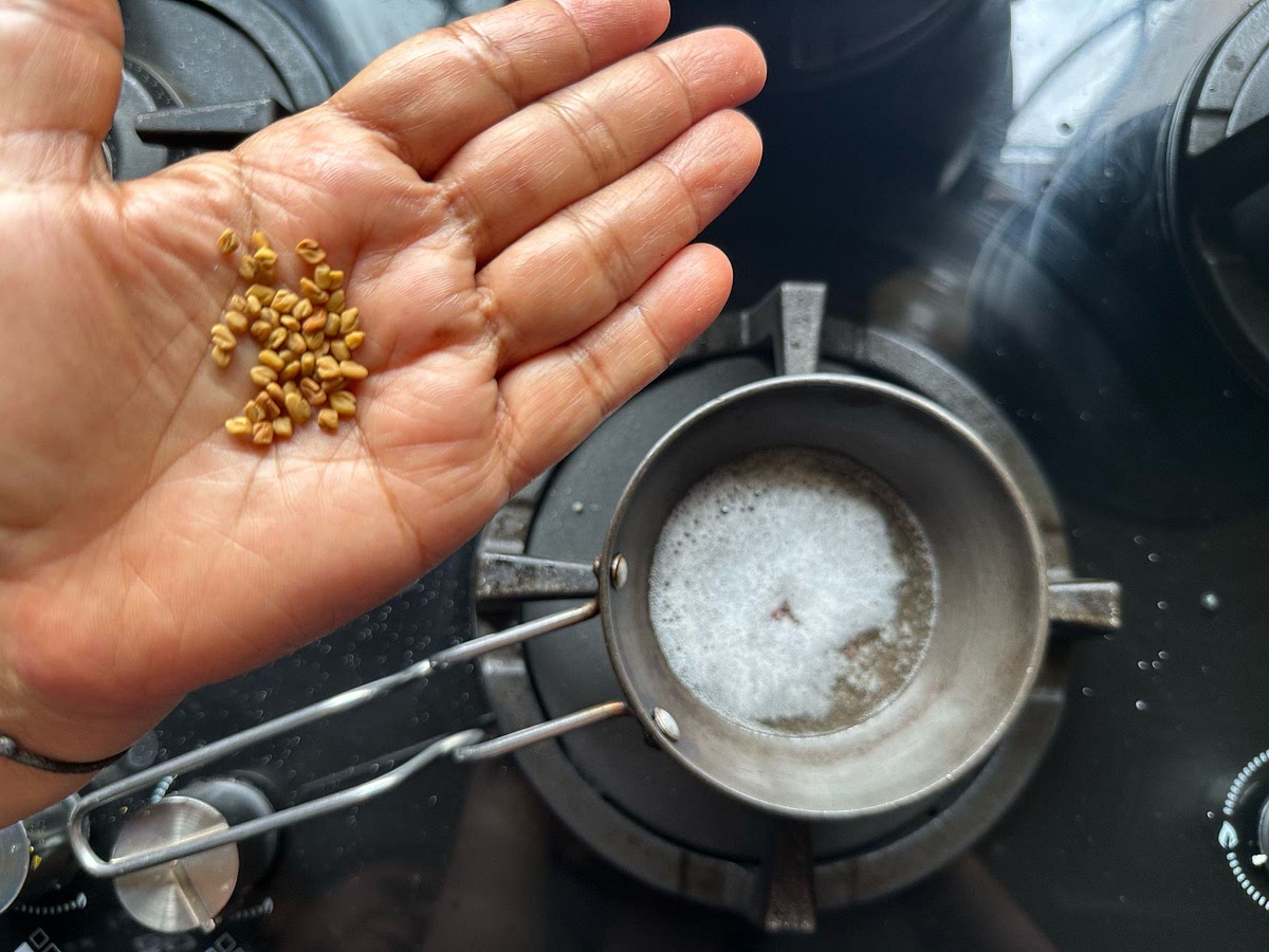 In a tadka pan, take coconut oil, and add mustard seeds. After they begin to cackle, add methi/fenugreek seeds.