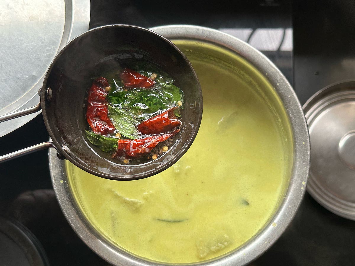 Take the tadka pan off the stove (so the ingredients don’t burn) and add curry leaves and dried red chillies.