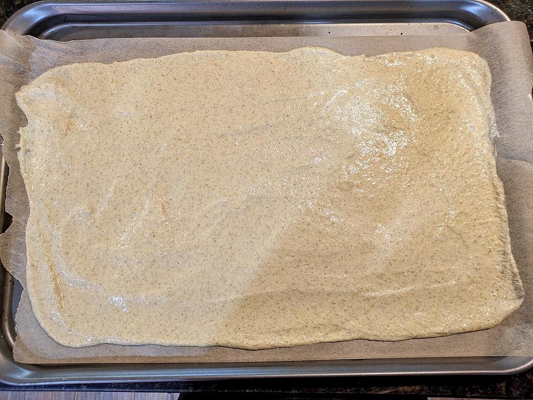 Preheat your oven to 350F, and line a large cookie sheet with parchment paper. Pour the batter onto your prepared baking sheet, and spread it thin to the edges of the pan.