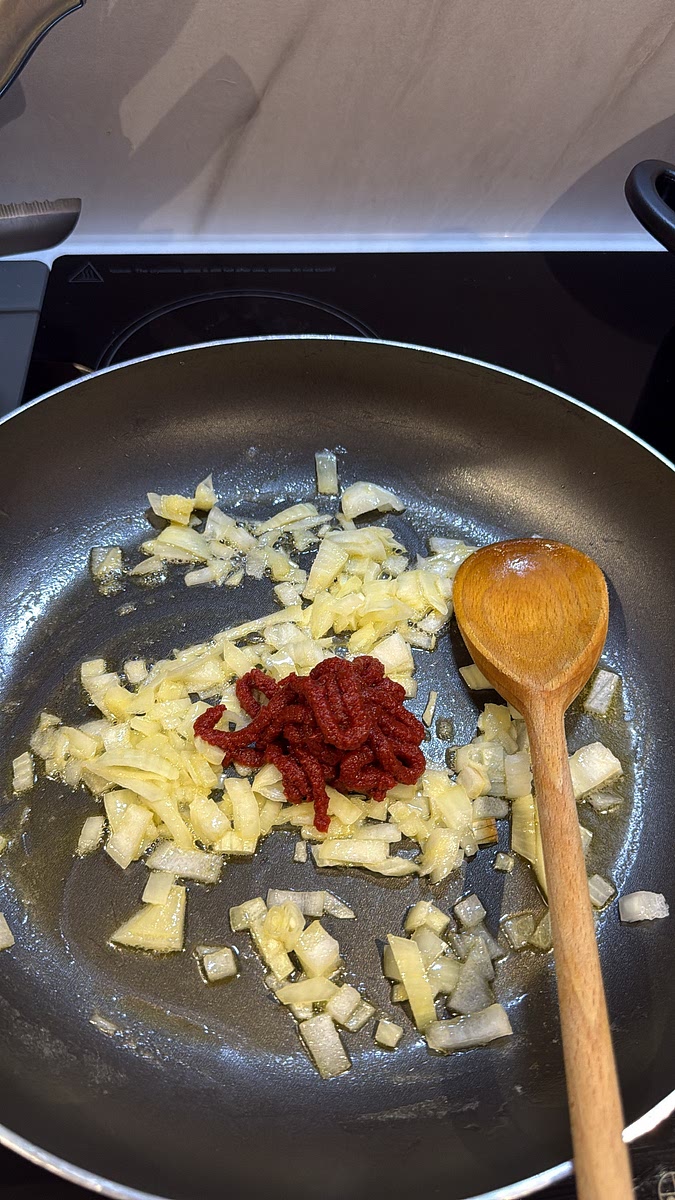 Stir in the tomato paste and let it cook with the onions for a couple of minutes.