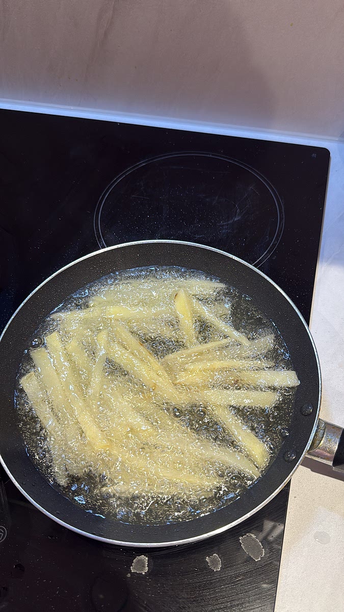 While the burgers are cooking, heat your frying oil and cook the homemade fries until crisp and golden. Drain well and season with salt.