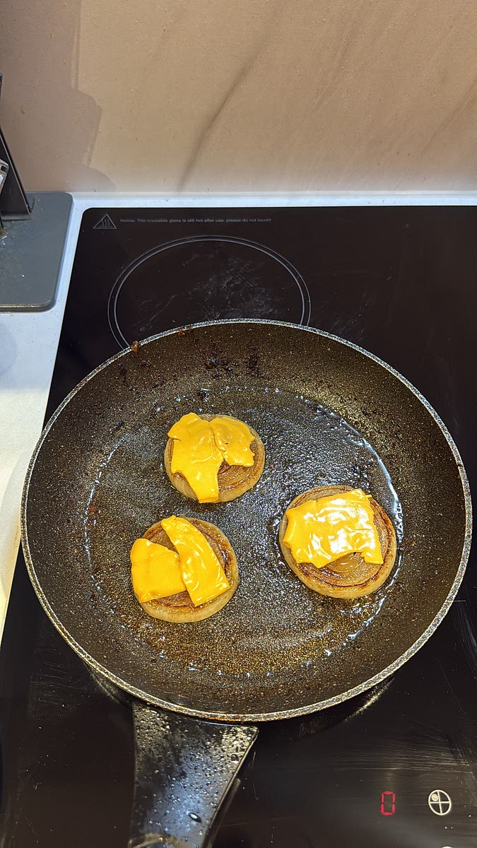 Return an onion round to the pan and add a little cheese on top to help everything stick together.