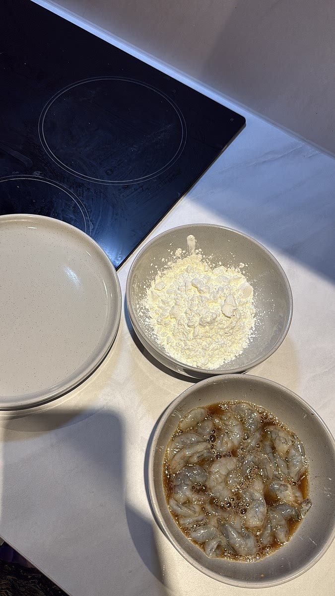 Place the cornflour into a separate bowl. Coat each prawn generously, pressing the cornflour onto the surface, then transfer to a clean plate.