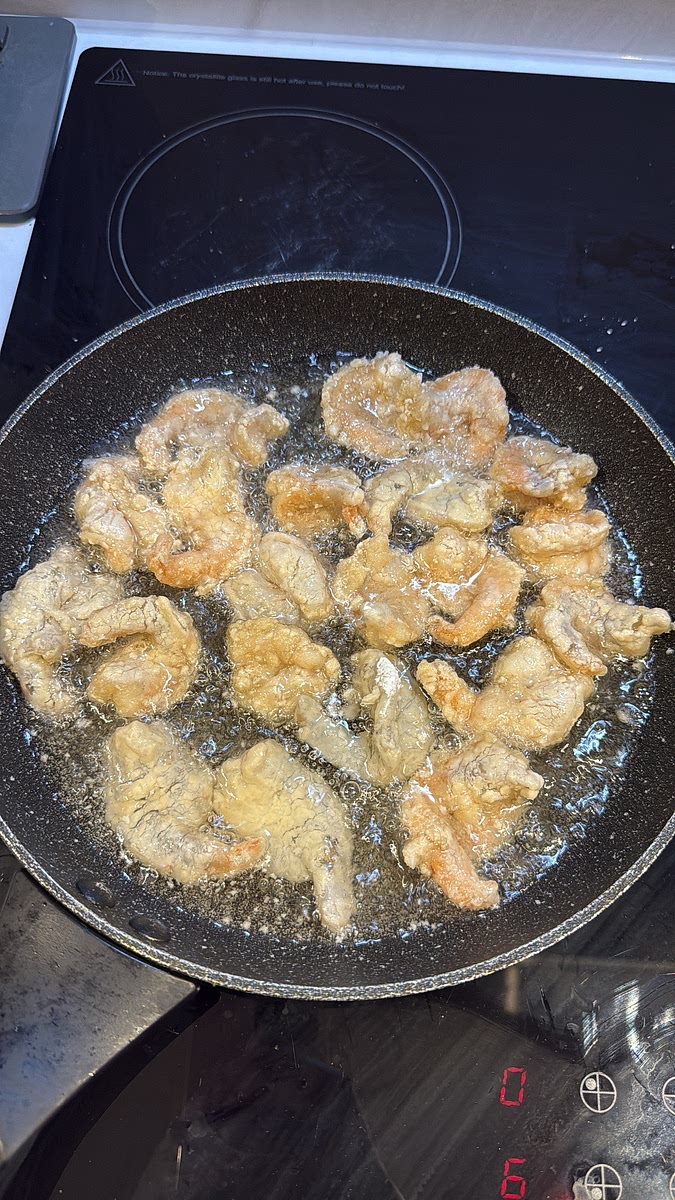 Heat vegetable oil in a frying pan. You can shallow-fry or deep-fry them. Start at a moderate heat so the prawns cook through without the coating browning too quickly, then increase the heat slightly towards the end for colour.