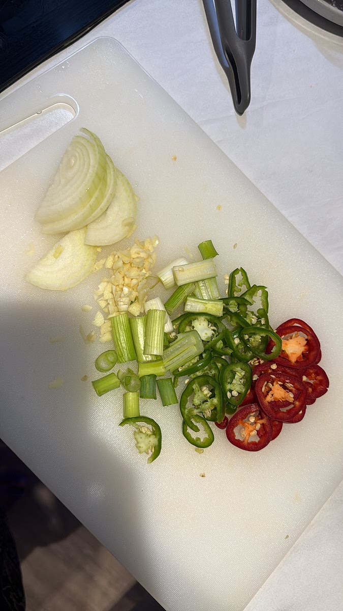 Slice the onion, spring onions and red and green chillies, then finely chop the garlic.