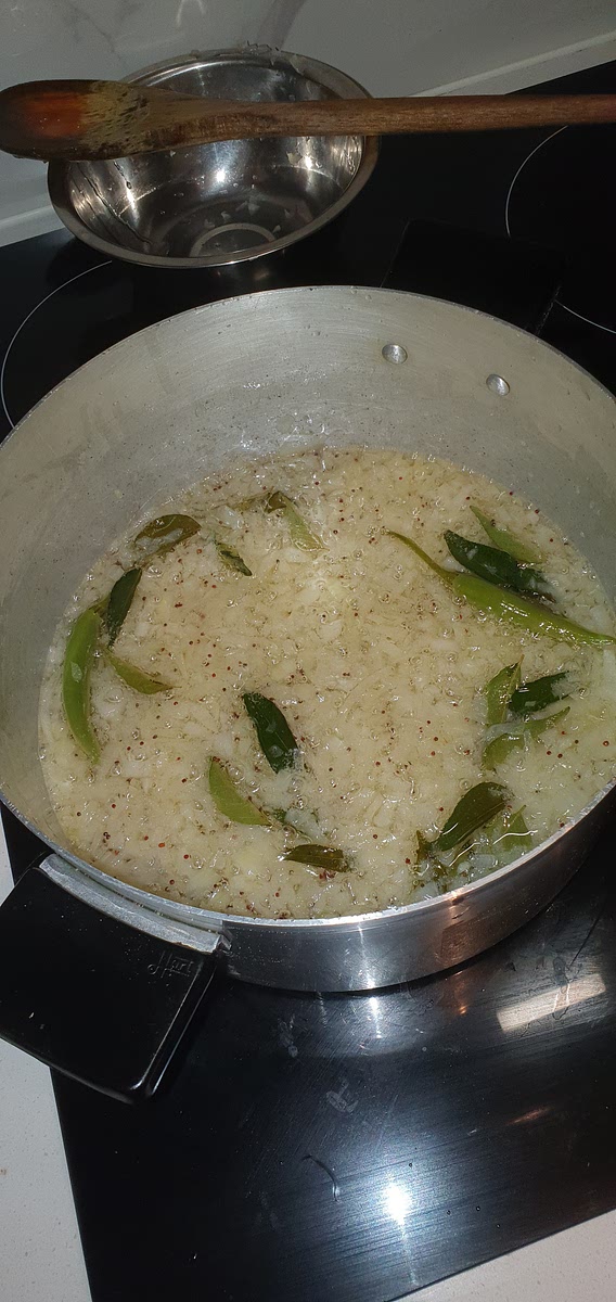 Once the temparature of the oil is sufficient for frying, add the onion, chilli's and curry leaves to the pot and fry for 6-8 minutes or until the onions become soft and golden.