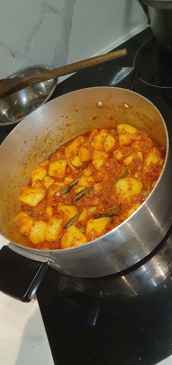 Add the drained potatoes to the pot and fry them for 5-8 minutes. Then add the blended tomatoes and cook on low heat for 10-15 minutes or until the oil separates from the tomatoes. Cooking uncovered will concentrate the flavours.