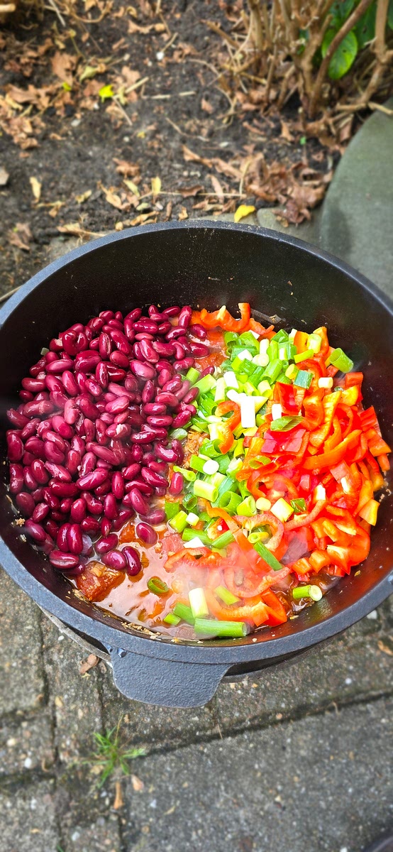 Doe de uitgelekte bonen erbij, net als de in repen gesneden paprika's en de in ringen gesneden lente-uitjes. Laat alles nog eens 1 uur sudderen.