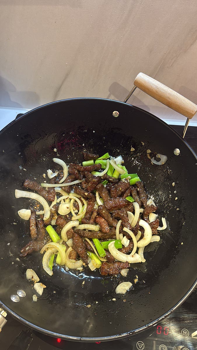 Return your crispy beef to the wok and toss everything together so the beef picks up all that garlic, ginger and onion flavour.