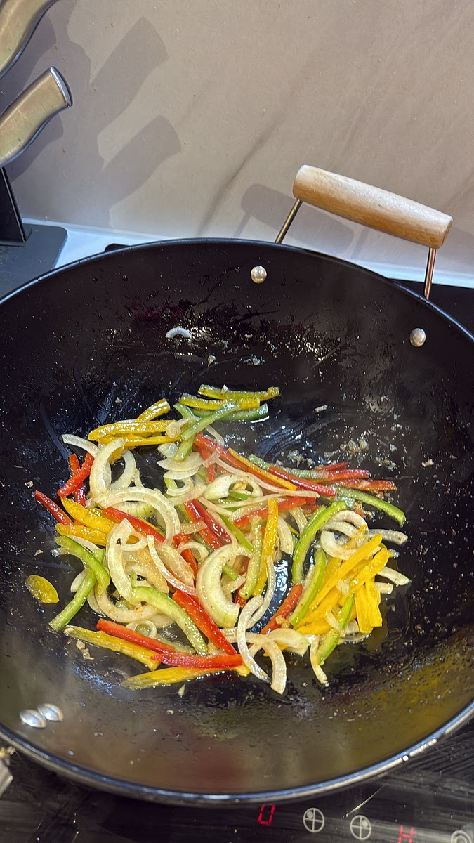 Remove most of the oil from the pan, leaving about 1 tbsp. Add the onion and peppers and stir-fry for 2 minutes so they soften slightly but still have a little crunch. Add the garlic, ginger and cook for another 30 seconds.