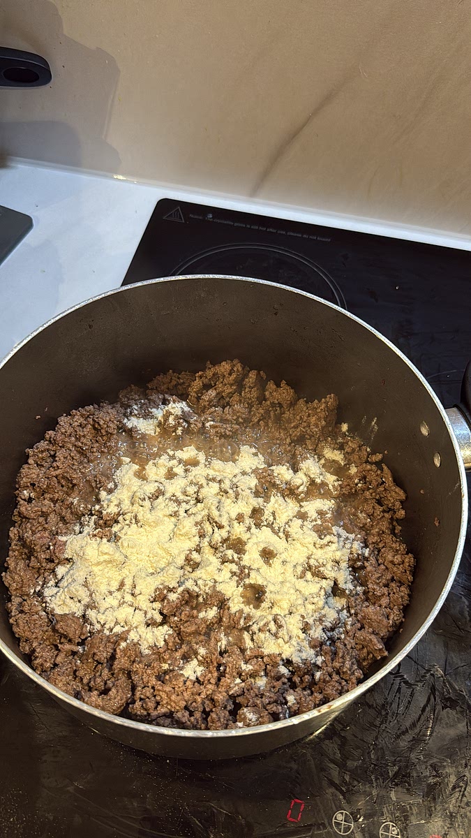 Sprinkle 1 tbsp plain flour over the cooked mince. Stir well so the flour coats the beef and cook it through briefly. This will help thicken that gorgeous gravy later.