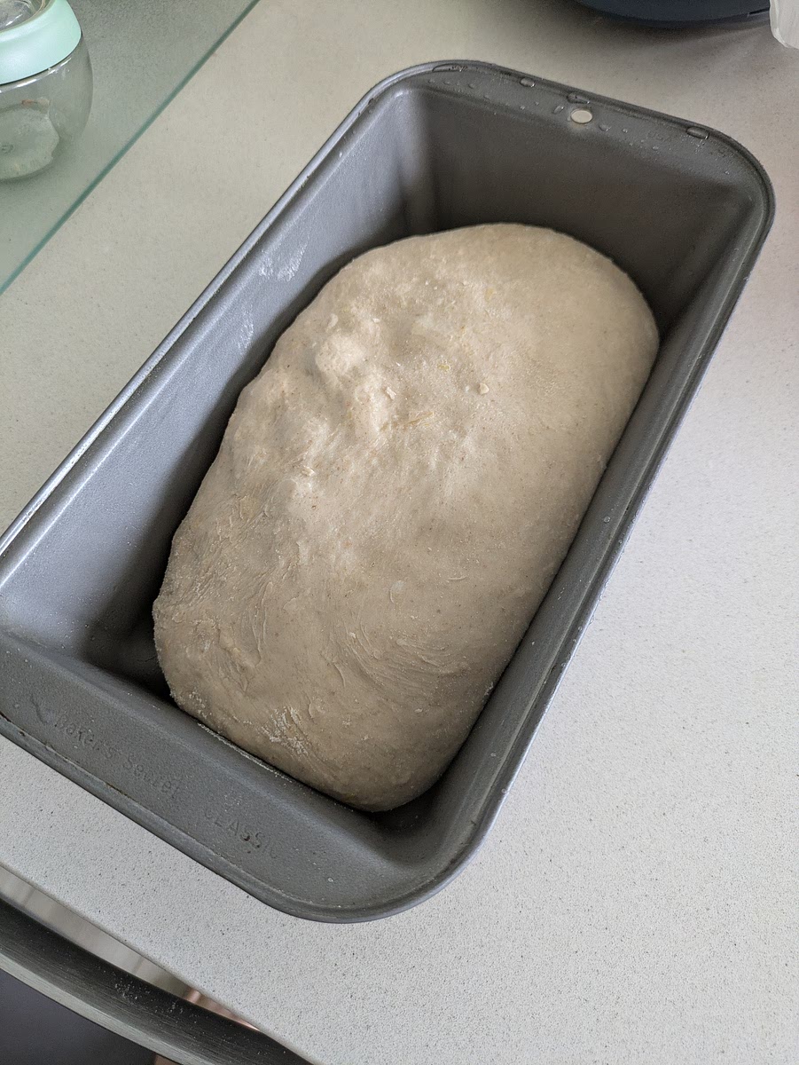 Dual-Steam Bake
Place an empty metal pan or cast-iron skillet on the bottom rack of your oven. Preheat the oven to 375°F (190°C) for 45 minutes.
Remove the cold loaf pan from the fridge and make one 1/4-inch deep slash straight down the center.
Dome tightly with aluminum foil over the top of the loaf pan, making sure it doesn't touch the surface of the dough.
Place the loaf pan on the middle rack and immediately pour 1 cup of hot water into the bottom metal pan to fill the oven with steam. Close the oven door immediately.
Bake covered with foil for 15 minutes.
Remove the foil tent and bake uncovered for 30 to 35 minutes at 375°F until the crust is golden-brown and the internal temperature reaches 205°F. (If the allulose causes the top to brown too fast near the end, loosely place a sheet of foil back over the loaf).