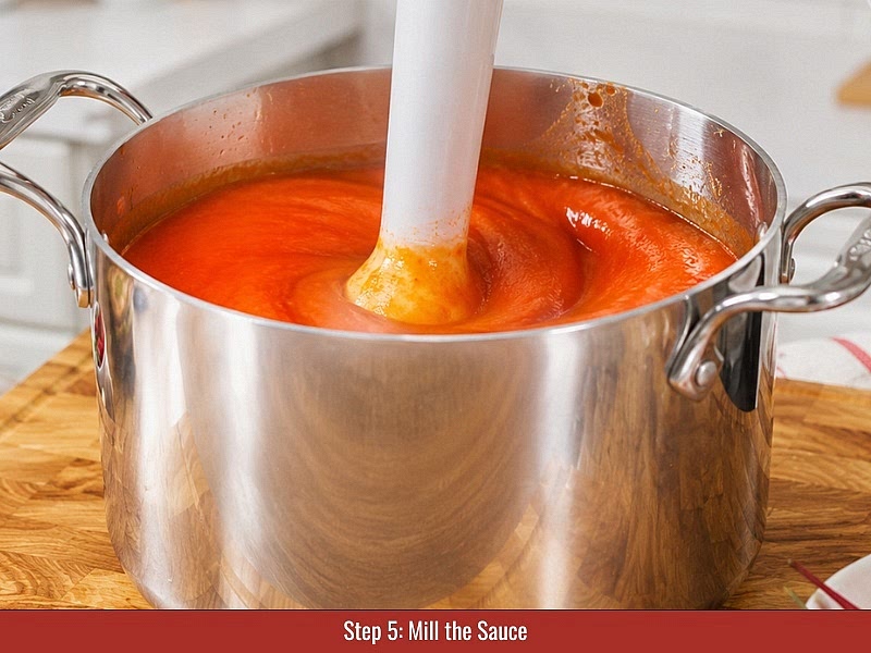 Mill the sauce: Run the blended sauce through a food mill to remove pepper skins and seeds. Transfer the smooth sauce into a saucepan.