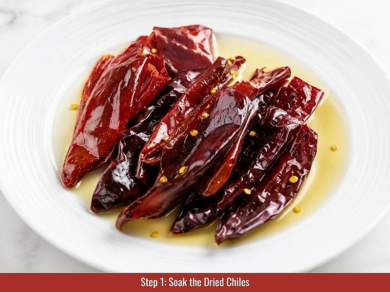Soak the dried chilies: Place dried New Mexico or Guajillo chilies in a heat-safe bowl and cover completely with hot water. Soak for 30 minutes until softened. Drain the chilies, then remove stems and seeds.