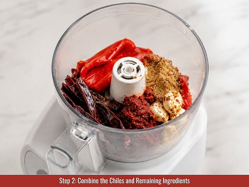 Combine the ingredients: Add soaked chilies, roasted red peppers, tomato paste, garlic cloves, caraway seeds, coriander, cumin, smoked paprika, cayenne pepper, lemon juice, and salt into a food processor.