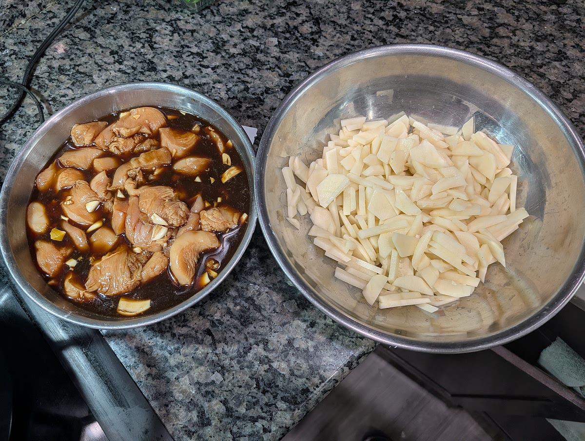 Cut chicken into small/medium cubes. Mash up garlic and remove peelings. Combine all other ingredients except oil in large bowl. Marinate for 15-30 min. Cut potatoes in small cubes or french fries and set aside.