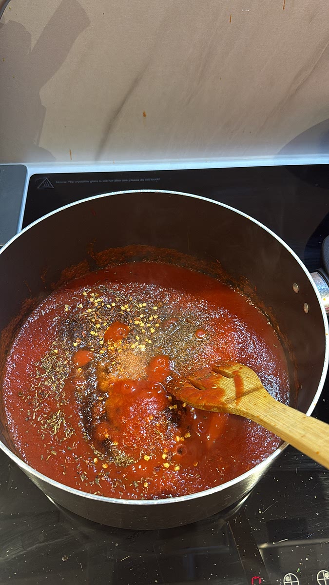 Pour in the passata and add the Italian seasoning, smoked paprika, all purpose, adobo, chilli flakes, sugar, salt and black pepper.