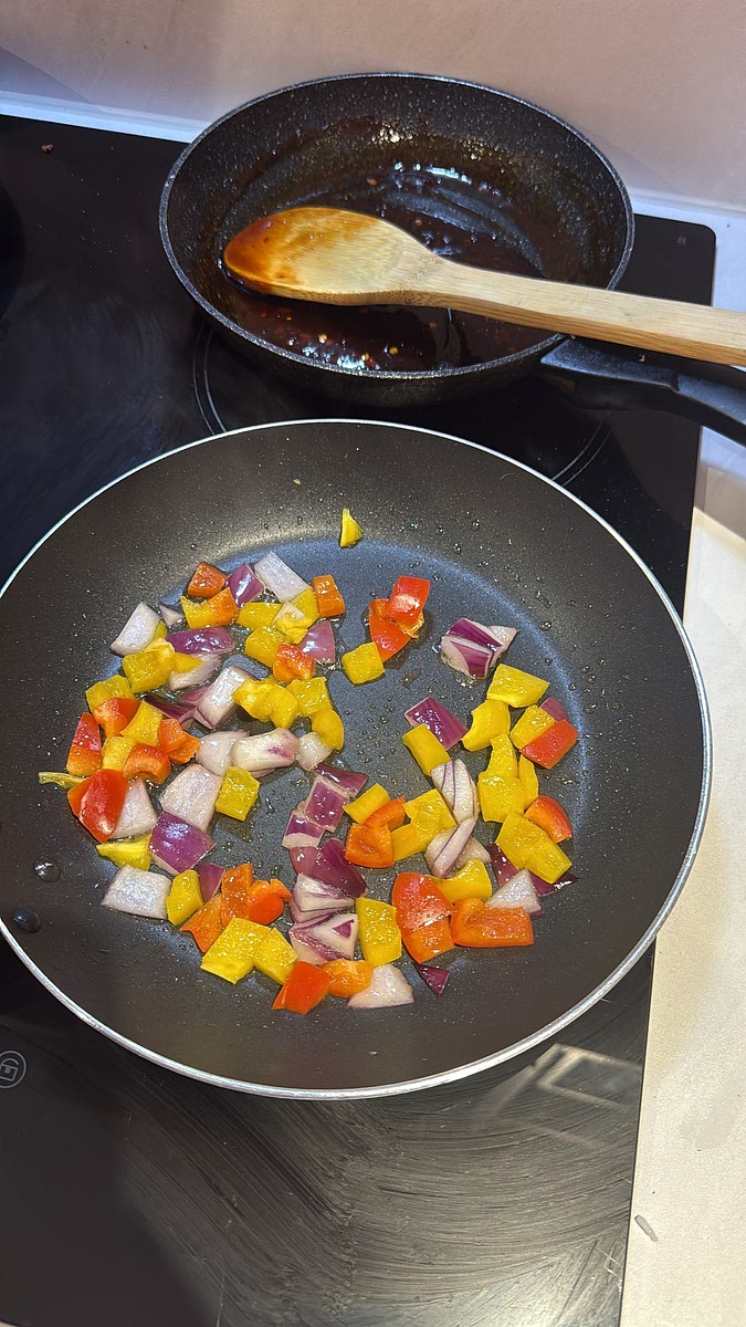 Add your bell pepper and red onion and stir-fry over high heat for 1–2 minutes. We want them slightly charred but still with some bite. Add the garlic for the final 30 seconds.