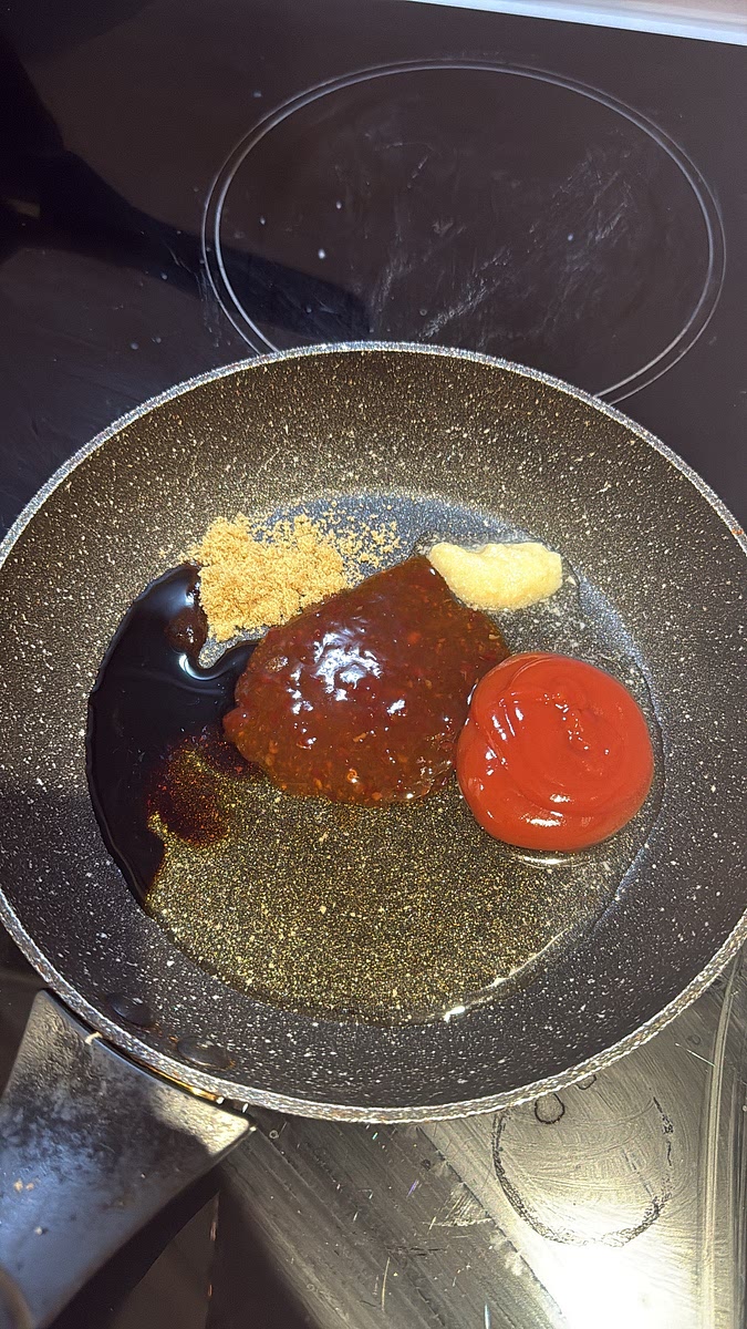 Lower the heat slightly. Add honey, sweet chilli sauce, ketchup, brown sugar, soy sauce, lemon juice, chilli and 1 tablespoon of water. Let it bubble for 1–2 minutes until it turns thick, glossy and syrupy.