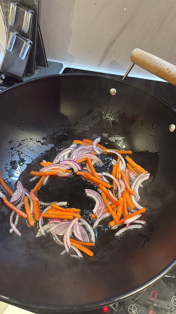 Into the same pan, add your red onion and bell pepper. Stir-fry over high heat for around 1–2 minutes so they pick up a little colour but retain some crunch. Finally add the chopped garlic and fry for around 30 seconds until fragrant.