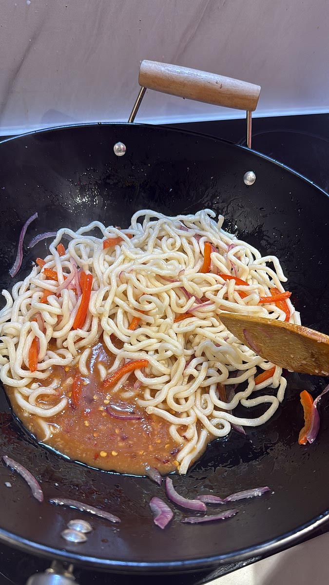 Give your sauce another stir because the cornflour will have settled. Pour it into the pan. Let it bubble for 30–60 seconds, tossing the noodles constantly.