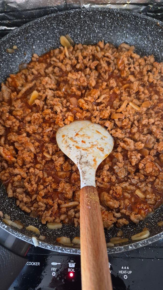 Am taiat marunt ceapa si usturoiul, le-am calit un pic in ulei si am pus carnea. Am calit si carnea si am lasat sa scada apa pe care o lasa. Am pus sare, piper, curry, boia, boia afumata, chimin macinat, miere, otet, sos de soia, pasta de ardei si bulion, am amestecat si am mai lasat la cea mai mica temperatura la cre inca fierbe un pic, cat sa se amestece gusturile cat de bine. Totul a durat vreo jumatate de ora. Condimentele si carnea la urma au stat cam 10 minute pe foc (sau, in cazul meu, pe plita)