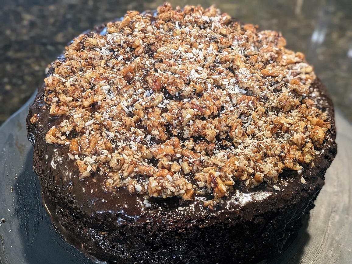 Add your remaining filling mixture (~115 g or 1/2 cup) on top of the frosting on top of the cake. Optionally garnish with more coconut flakes.