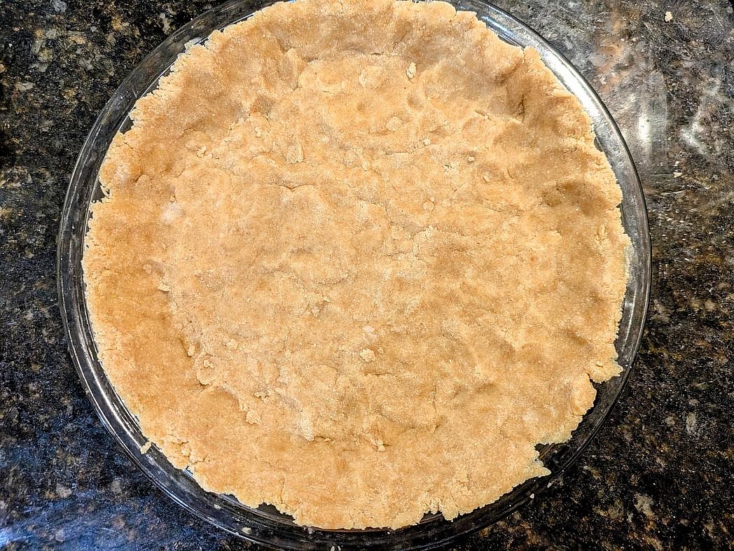 Press about 3/4 of your crust dough (~276 g) into a 9" pie pan, reserving any leftover scraps.