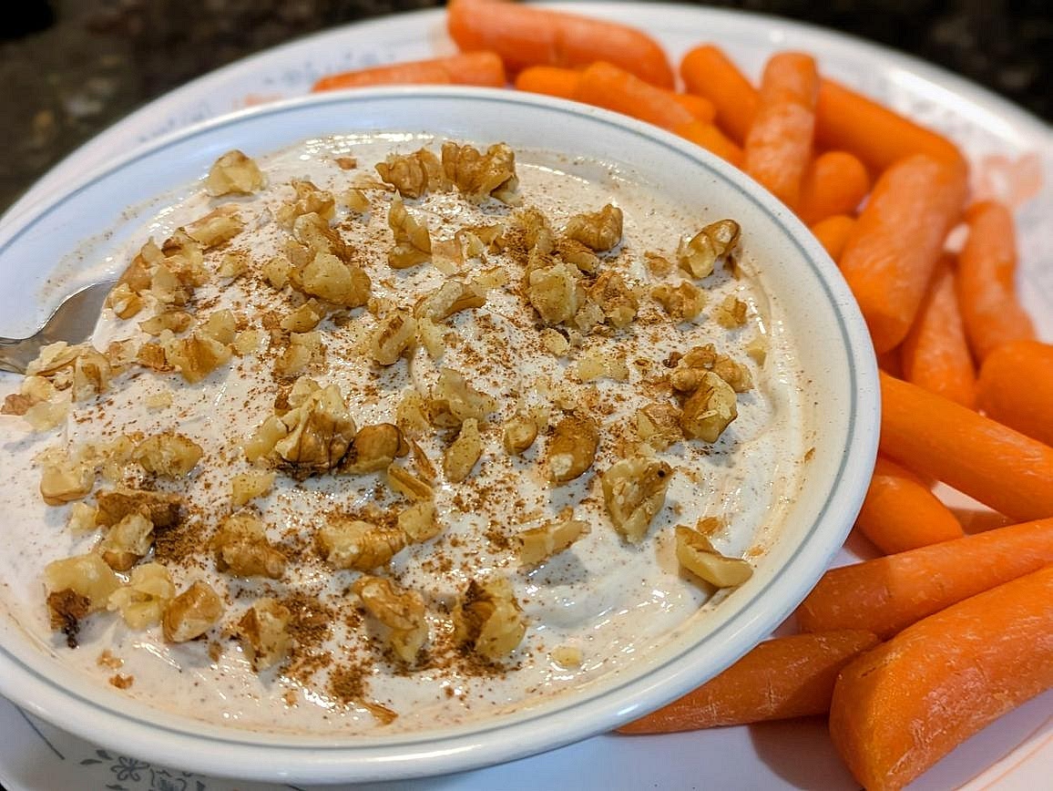 Mix together yogurt, cinnamon, pure granulated monk fruit, ginger, nutmeg, cloves, salt, and vanilla in a small bowl. Top with chopped walnuts. Serve with carrots for dipping.