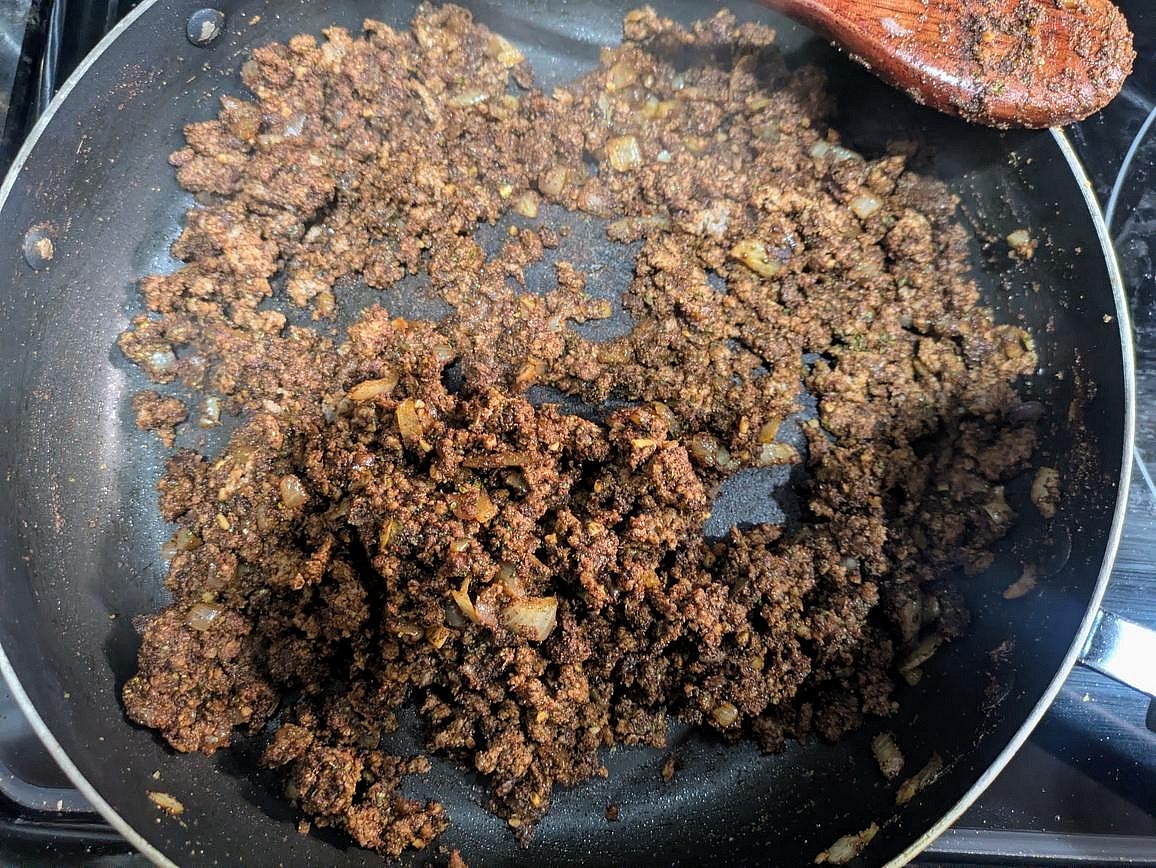 Meanwhile, heat a large pan over medium heat with olive oil. Cut an onion into a small dice. When the oil is hot, add in onion, and cook until it starts to turn translucent, about 5 minutes. Add in the meat, and press it down as much as possible to make sure as much of meat is touching the pan. Let it sear for about 5 minutes without touching it to develop good browning, until fragrant. Mash with a wooden spoon, and continue cooking until no longer pink. Make a hole in the center, and add the garlic to the pan. Cook for about 30 seconds, until fragrant. Add in the lime juice and water, and mix the lime and garlic into the meat.