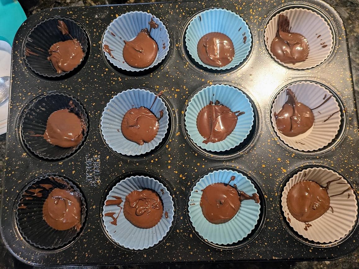 Add 1/2 tbsp (7.5 g) of melted chocolate to the bottom of each muffin cup, and tilt the pan to cover the full bottom.