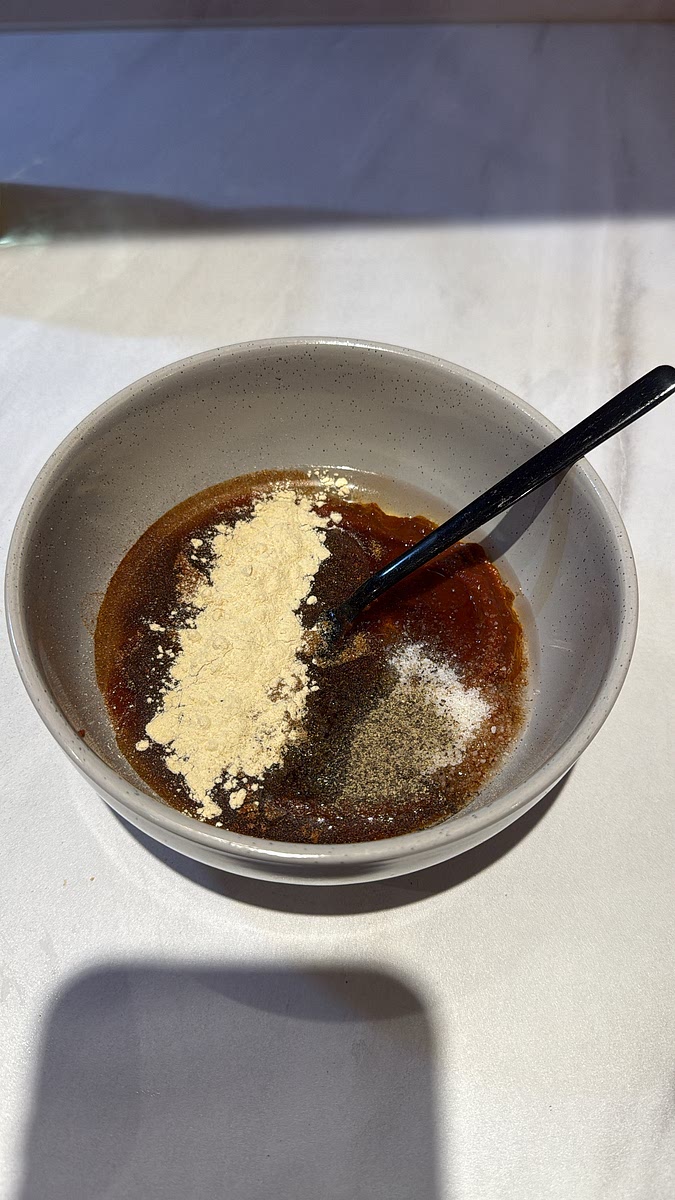 In a bowl, combine the harissa paste, honey, olive oil, minced garlic, lemon juice, smoked paprika, cumin, onion powder, salt and black pepper. Mix until smooth. Reserve approximately 4 tablespoons of marinade in a separate bowl before adding the raw chicken.