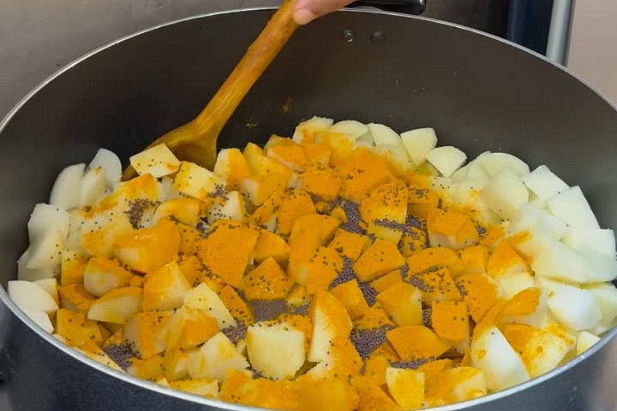 Combine potatoes and spices: Add 4 kilograms potatoes, peeled and cubed into roughly 1 inch pieces, 3 teaspoons turmeric, 100 milliliters oil, 4 teaspoons salt, 3 teaspoons MSG and 3 teaspoons black mustard seeds to a large heavy-based pot. Mix well to coat the potatoes thoroughly in the oil and spices.