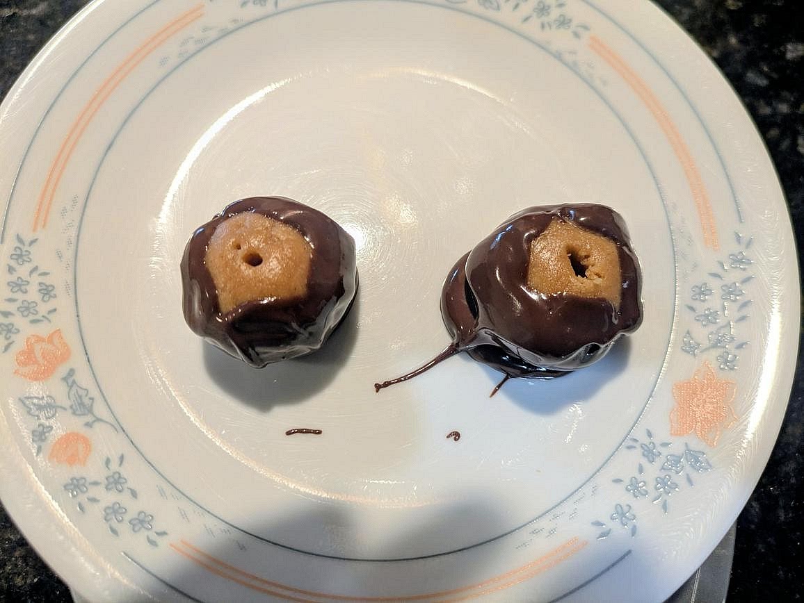 Dip each peanut butter ball into the melted chocolate, coating the bottom and sides, but not the top. Return to the plate, and remove the toothpick. Chill in the fridge for 30 minutes for the chocolate to harden before serving.
