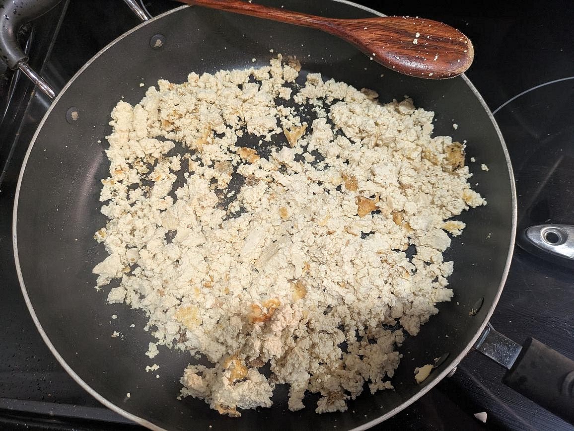Heat a large pan over medium heat with oil. When hot, add in the drained block of tofu. Let it sear without touching it for about 5 minutes to develop browning before mashing with a wooden spoon. Cook for an additional 5 minutes, or until the water has cooked off. Transfer the cooked tofu to a large slow cooker.