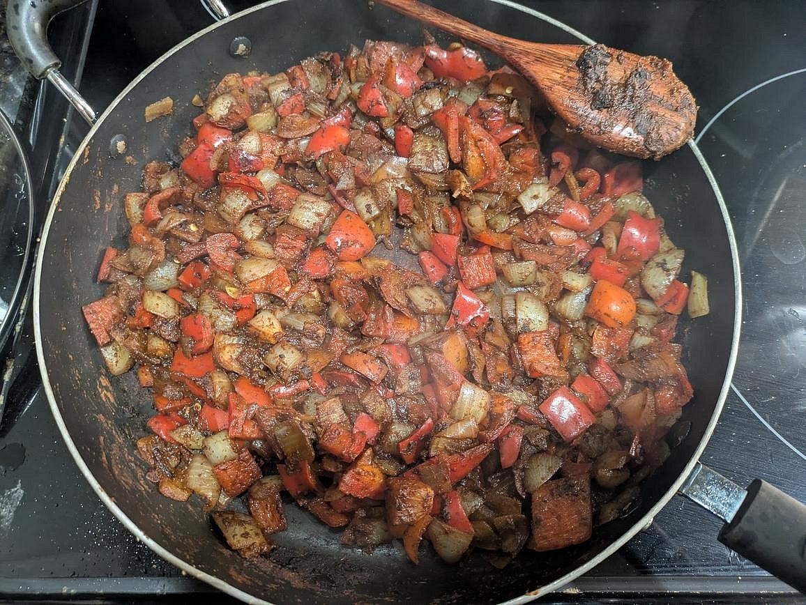 Meanwhile, cut your peppers and onions into a medium dice. Once the pan from the tofu is empty, add in your oil, peppers, and onions with chili powder, cumin, and salt. Add a splash of water, cover, and cook with occasional stirring over medium heat until soft, about 10 minutes. Transfer the veggies to a large slow cooker.