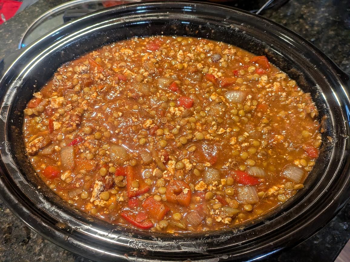 In your slow cooker, add crushed tomatoes, diced tomatoes, minced garlic, and cocoa powder. Mix with the lentils, tofu, and veggies.